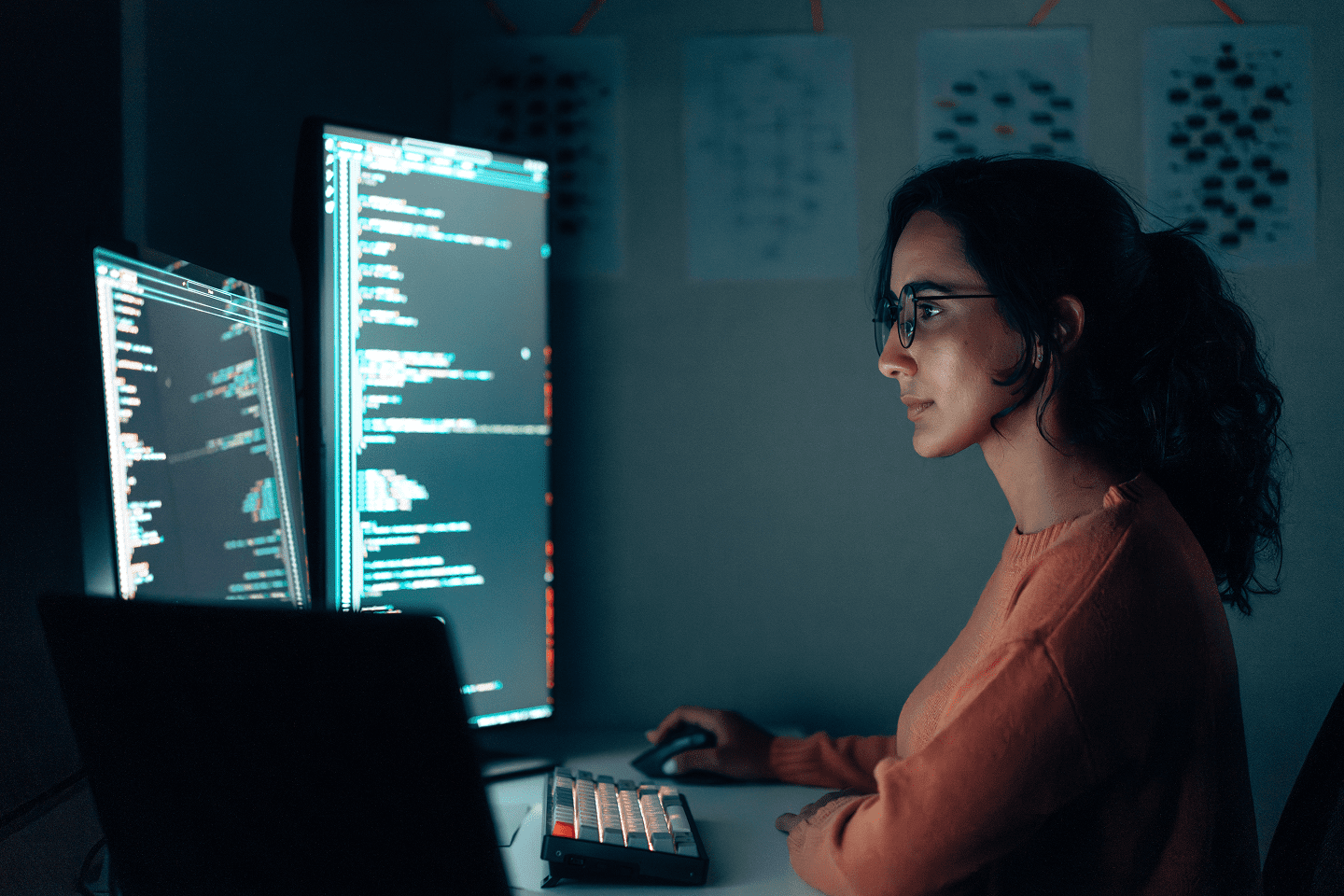 Woman coding at dual monitors